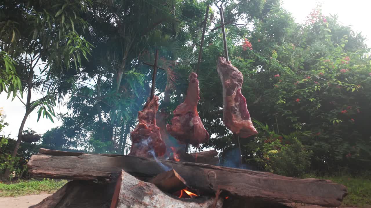 Traditional Venezuelan "carne en vara" cooking over an open fire