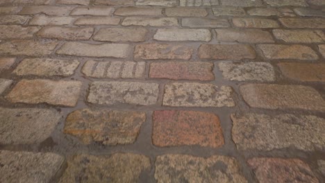 wet cobblestone road after rain, closeup moving forward