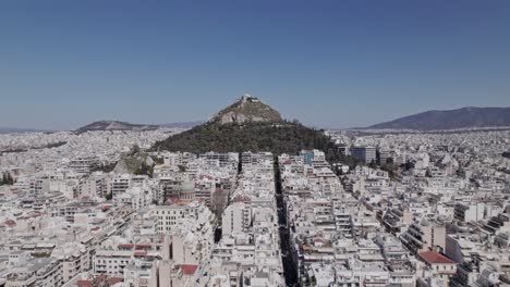 Flying-around-Mount-Lycabettus-in-Athens,-Greece