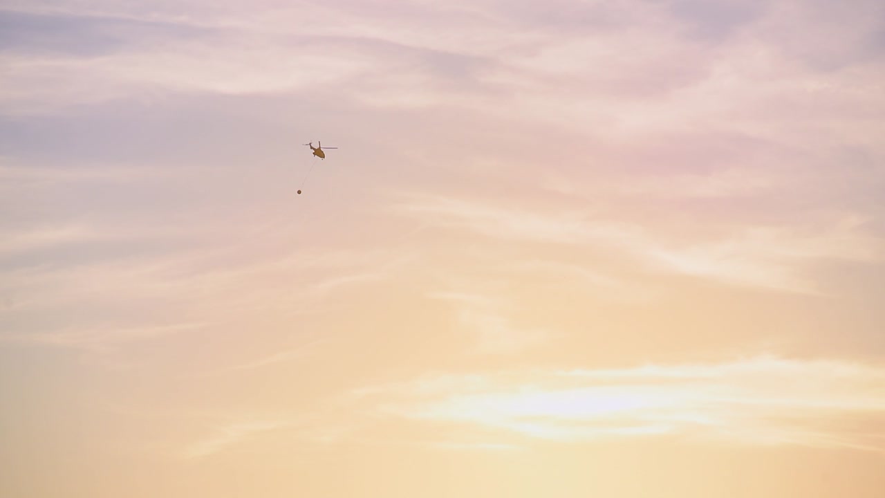 일몰 위를 비행하는 소화 헬리콥터