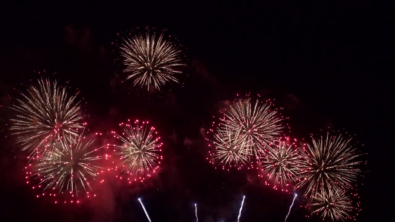 Spettacolari fuochi d'artificio ed esplosioni pirotecniche nel cielo notturno, scintille colorate sopra la città durante i festeggiamenti.