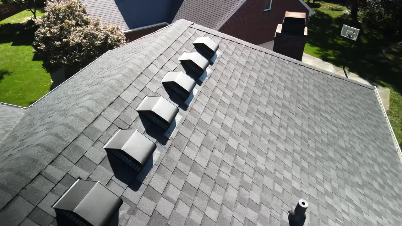 Aerial drone shot focusing on the vents of a newly installed roof. Perfect footage for showcasing roofing ventilation systems and construction details.