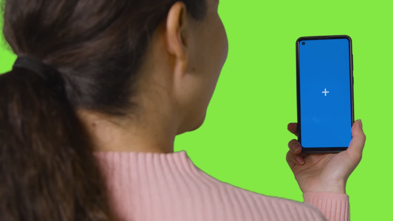 푸른 화면에서 비디오 통화를 하는 여성의 뒤쪽 뷰  ⁇ 은 녹색 화면에 대한 휴대 전화