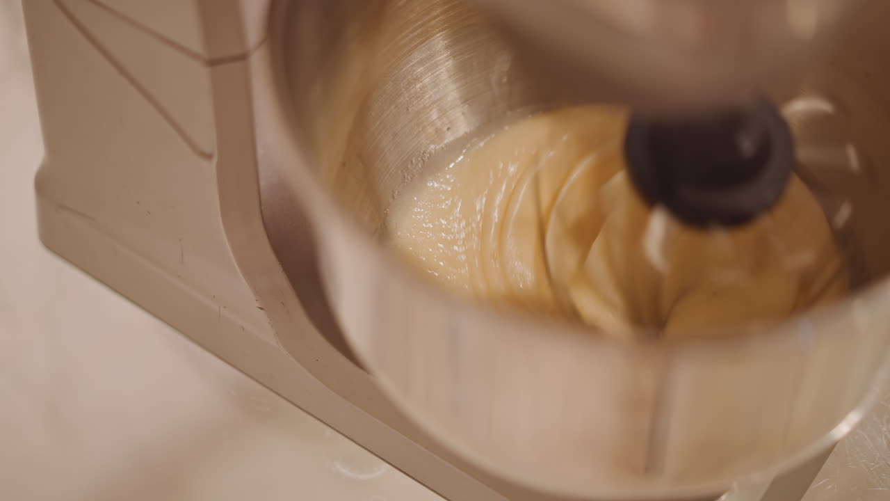 Pumpkin filling blending. Mixer smoothly combines pumpkin mixture. Closeup of mixer blending pumpkin filling evenly. Steady whirring of mixer blending spicy pumpkin pie ingredients clearly