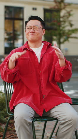 sad unhappy frustrated asian man sitting alone in city street feeling bad annoyed grief problem