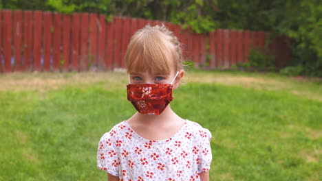 portrait of a cute little girl wearing a protective face mask