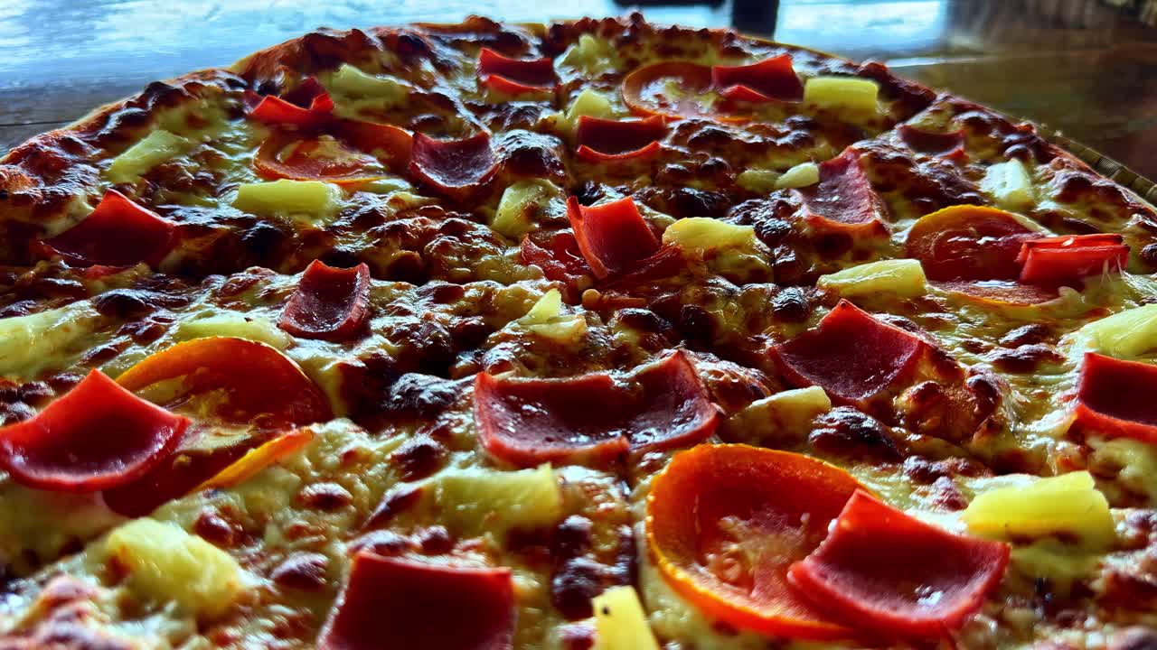 Pizza al forno condita con formaggio, peperoni e ananas sulla crosta, Moalboal, Filippine