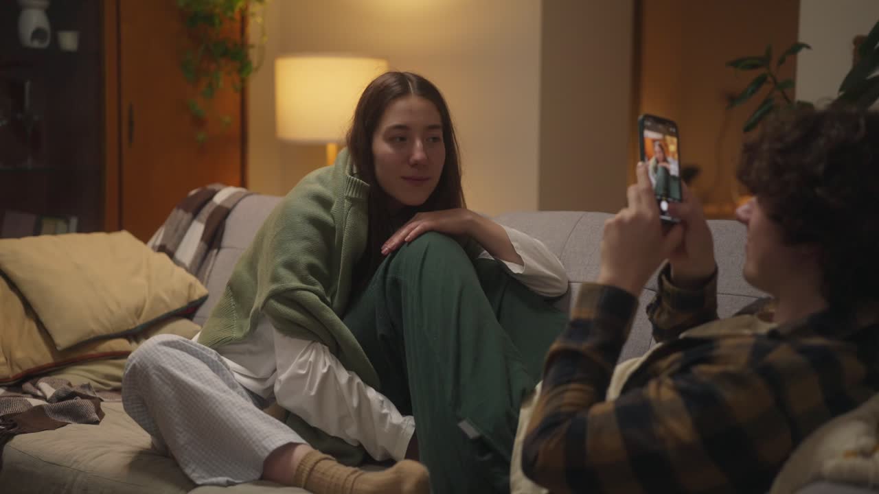 Couple taking pictures at home