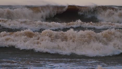 sea storm with big waves at sunset