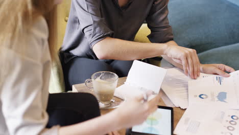 Mujeres-De-Negocios-Reunidas-En-Una-Cafetería-Usando-Una-Tableta-Digital