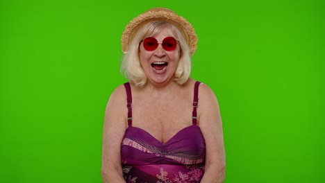 Amazed-senior-pensioner-woman-tourist-in-swimsuit-shocked-by-sudden-victory-saying-wow-on-chroma-key