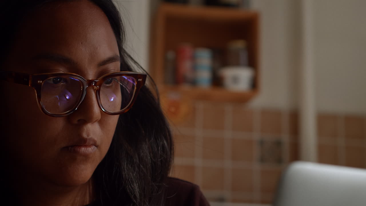 Woman concentrates on her work on her laptop in an apartment