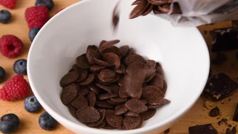 pouring chocolate cereal into a bowl for breakfast