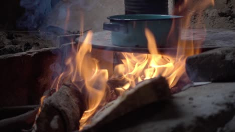 disparo en cámara lenta de comida siendo cocinada en una olla en un gran fuego de campamento