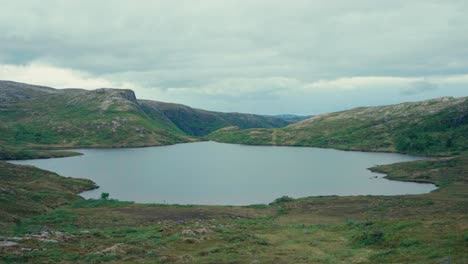 osen, trøndelag county, norway - a picturesque lake, pålvatnet, encircled by lush green hills - handheld shot