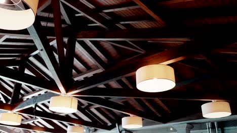 dark wooden truss ceiling with circular pendant lights in stylish contemporary hall