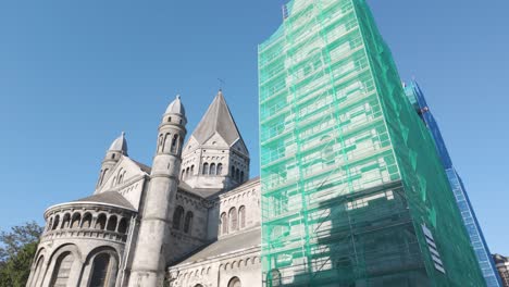 notre dame and saint remacle church in spa, belgium, with scaffolding for restoration under clear skies