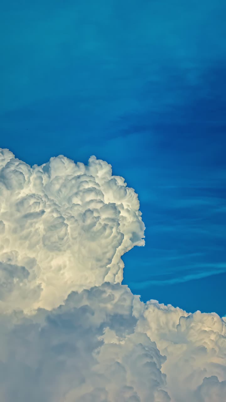 Vertical timelapse of towering clouds against vibrant blue sky
