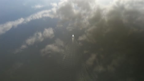 aerial orbit over a lonely yacht sailing on the calm dark waters in northern europe