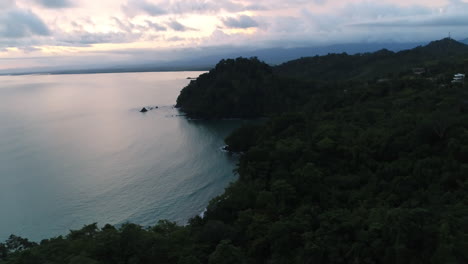 sunrise aerial over heavily forested pacific coastline panning down, 4k