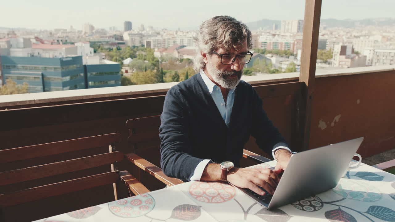 Uomo che lavora al computer portatile con vista sulla città