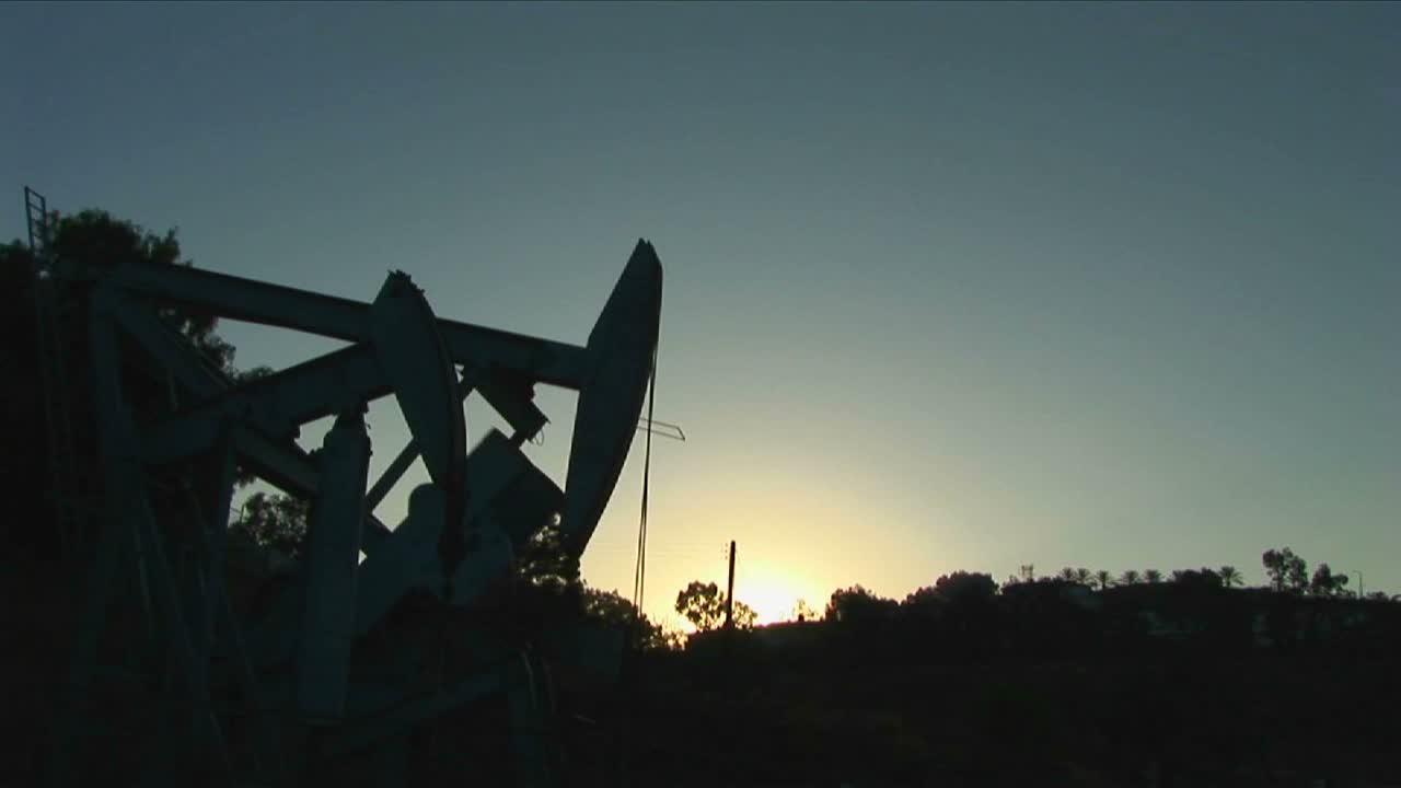 una torre de perforación de pozos de petróleo se recorta contra un cielo brillante