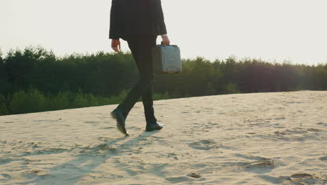 a businessman with a case in his hand walks along a sandy beach 1