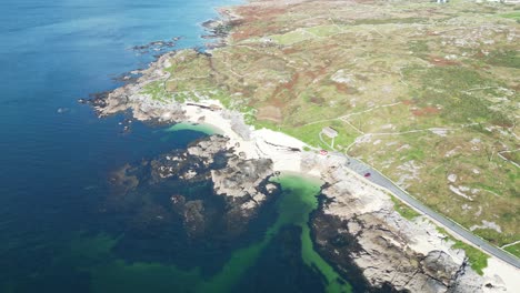 aerial view of a rocky coastal landscape with clear blue water, various bays and beaches and a coastal road at coral beach in connemara galway, ireland