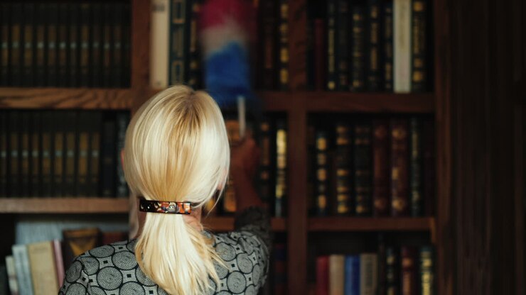 Bibliotecario che pulisce le librerie