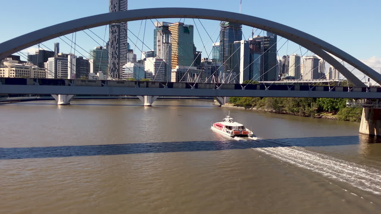 Brisbane City Cat sails under bridge on river