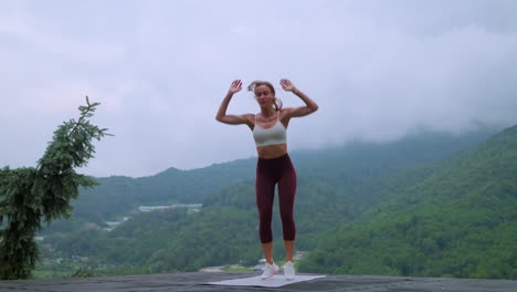 mujer haciendo ejercicio de tabla al aire libre en las montañas