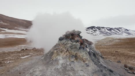 icelandic active steam vent formation push out white vapor during windy day