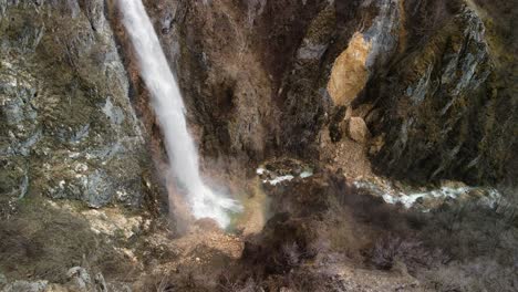 splashing water against rocks falling from an overhang