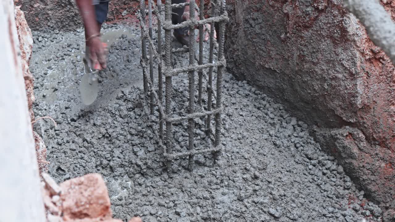 Worker Pouring and Leveling Concrete for Column Foundation at Construction Site. day time, stable shot, top down shot, 4k