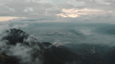 Antena-De-Drones-Volando-Alto-Sobre-Las-Nubes,-Vista-Al-Lago-Amatitlan-Y-Montañas-En-Guatemala