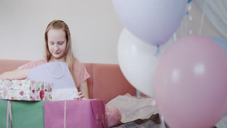 한 아이 가 생일 선물 을 풀고 있다