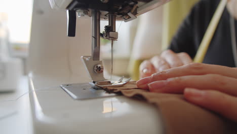 hands of seamstress using sewing machine