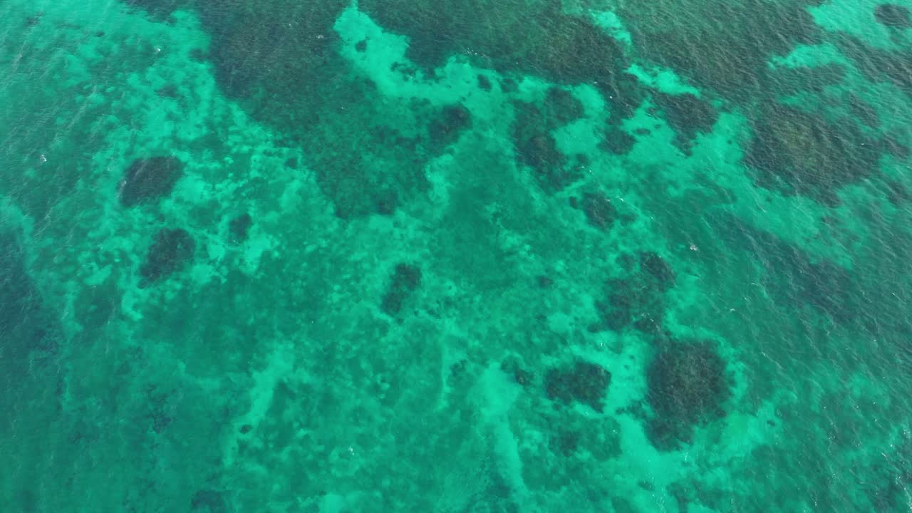 Aerial drone tops down blue turquoise waters in slow motion