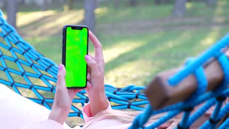hands holding horizontal chromakey mobile phone at city closeup woman online hands holding horizontal chromakey mobile phone at city closeup unknown woman reading news at green screen device anonymous executive resting online at urban district blonde boss looking display