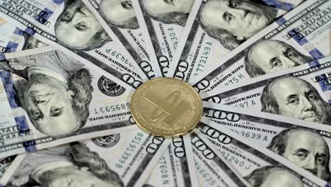 money neatly arranged in radial pattern with shiny gold tangible usdt tether coin at center of hundred dollar usd bills