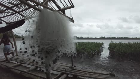 Una-Filmación-Estacionaria-De-Una-Red-De-Pesca-Colgada-Al-Costado-De-Una-Choza-De-Bambú