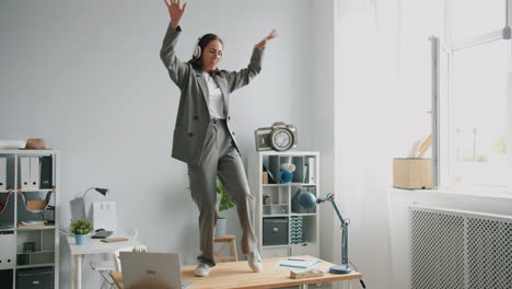 woman dancing on a desk in an office