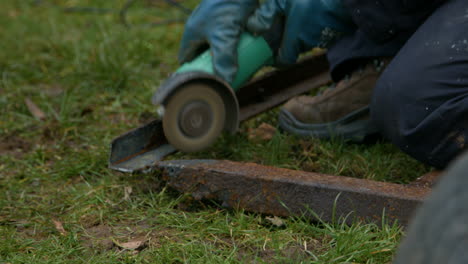 Worker-Using-Grinder-on-Rusty-Old-Metal-with-Sparks-Flying-Whilst-Wearing-Protective-Gloves-and-Overalls