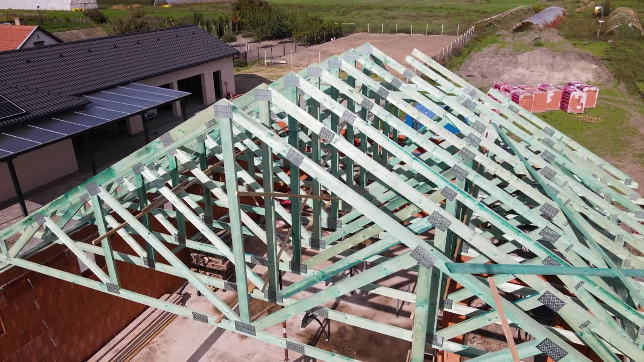 Wooden roof framework installation during brick block house construction