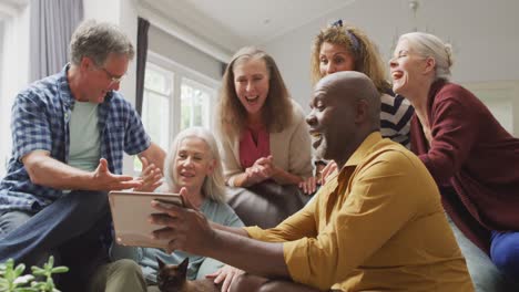 animación de felices y diversas amigas y amigos mayores usando tableta en casa