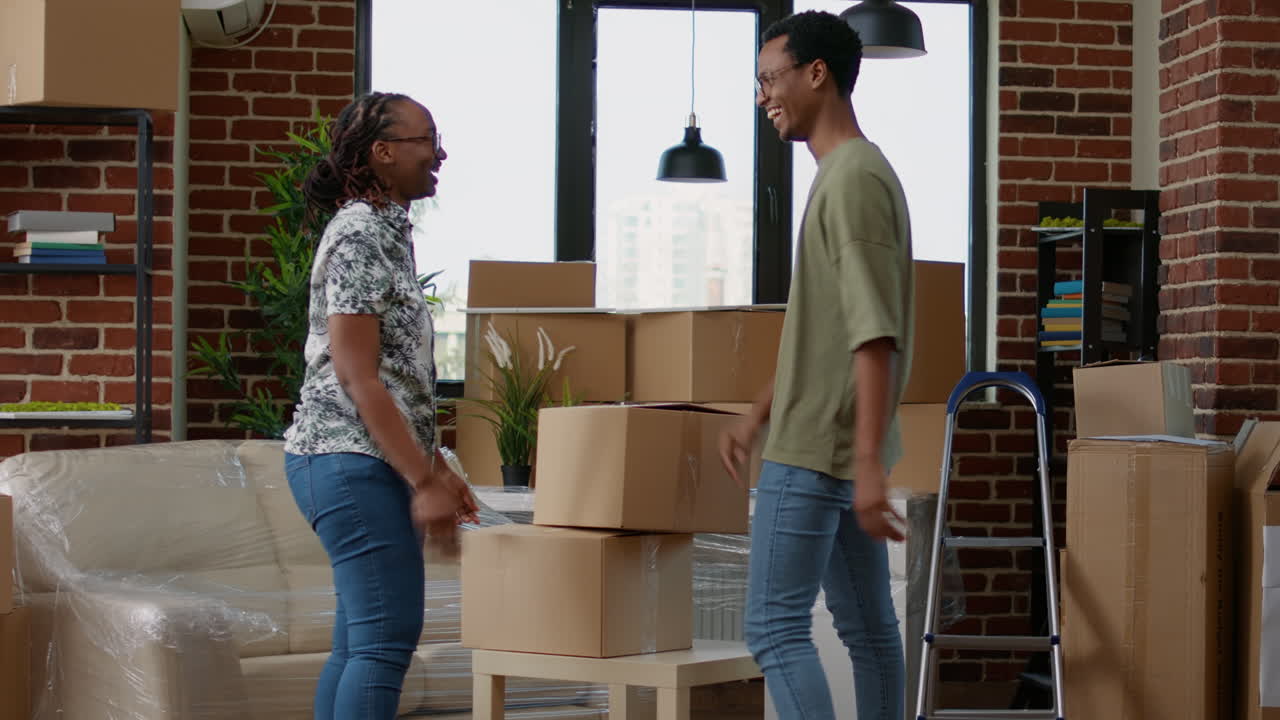 Husband and wife moving in new home with carton boxes