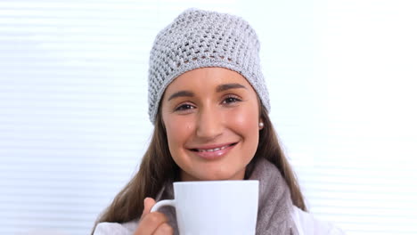 Mujer-Joven-Con-Sombrero-Y-Bufanda-Oliendo-Su-Taza