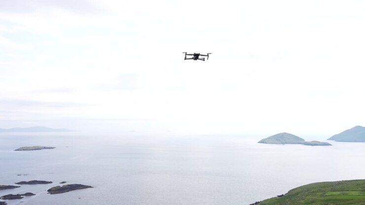 Inquadratura statica di un drone che vola immobile a mezz'aria e poi si muove indietro verso il mare, Ring of Kerry.