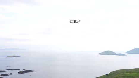 Toma-Estática-De-Un-Dron-Volando-Aún-En-El-Aire-Y-Luego-Retrocede-Hacia-El-Mar,-Anillo-De-Kerry