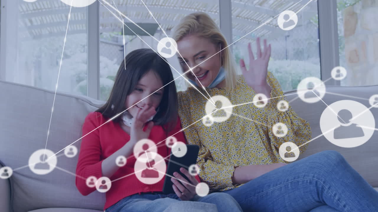 animación de iconos de los medios sobre una madre y una hija caucásicas con máscaras faciales usando smatrphone